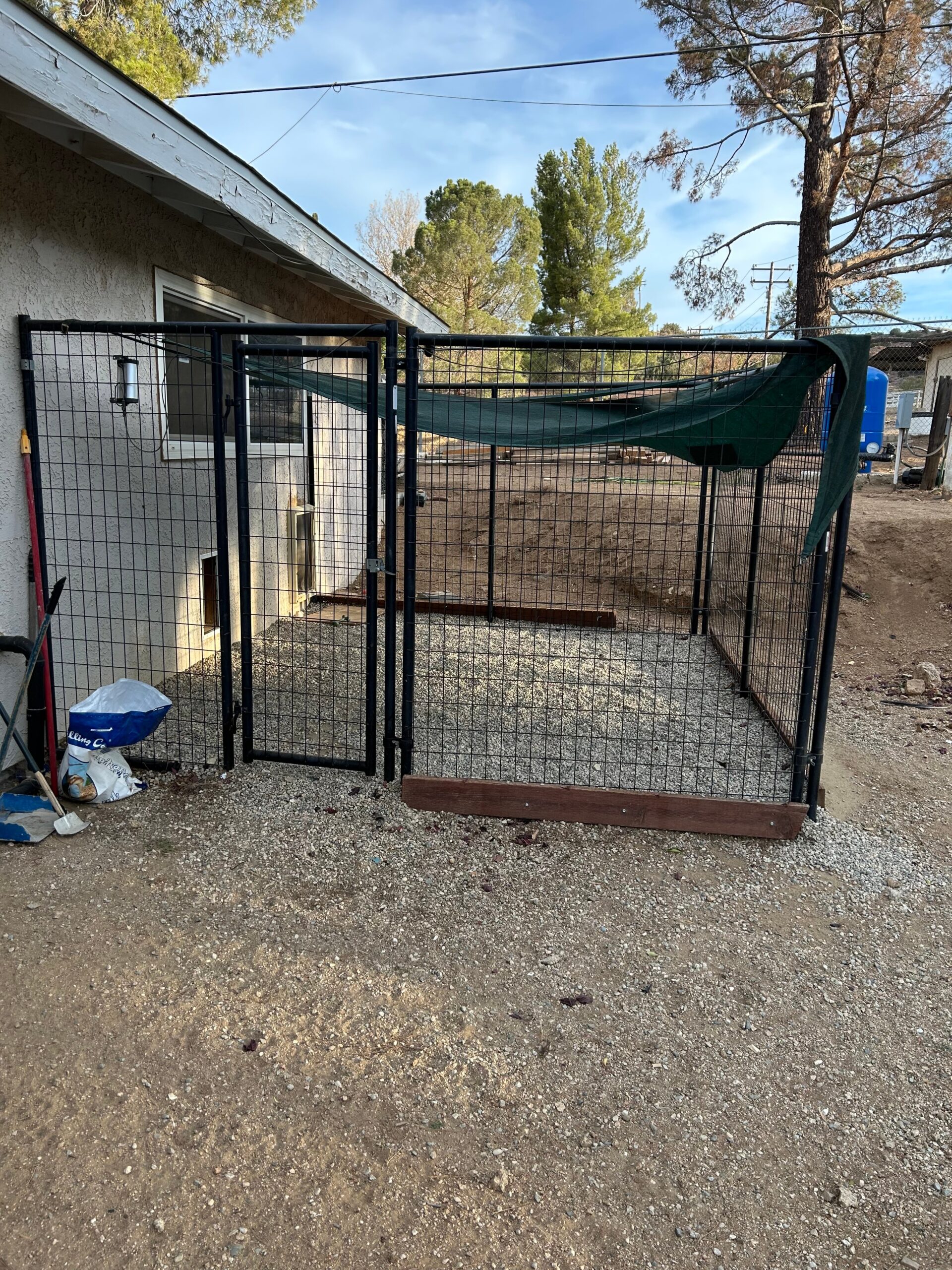 Enclosed outdoor pet kennel featuring a wire fence